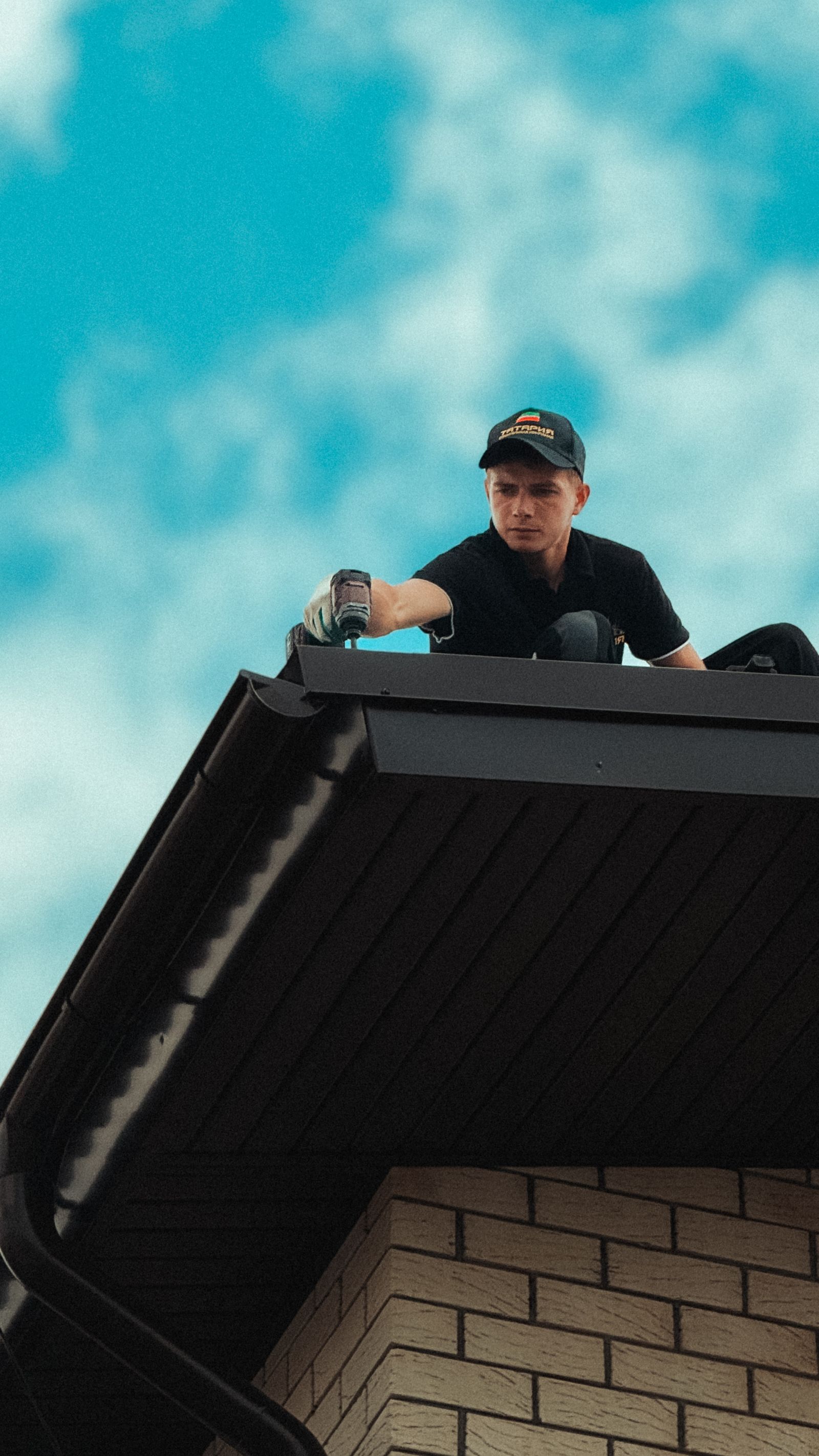 A roofer working at the edge of a steep residential roof